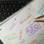 Close-up of notebook with SEO terms and keywords, highlighting digital marketing strategy.